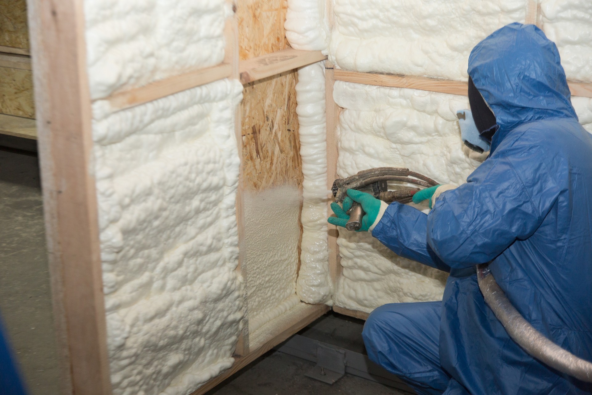 The worker insulates the walls of the house with foam for sound insulation and heat